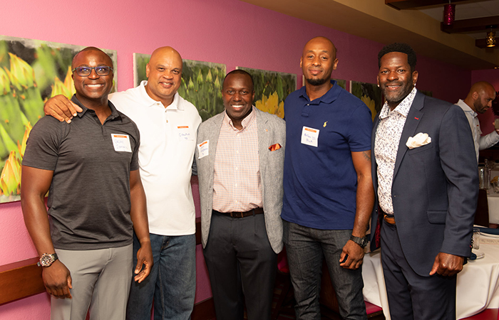 Football alumni pose for a photo with Deon Maddox.
